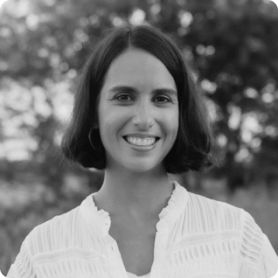 Julia Frydman wearing a white blouse and smiling at the camera