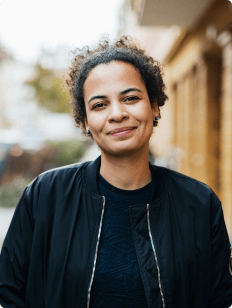Woman with dark curly hair smiling at the camera