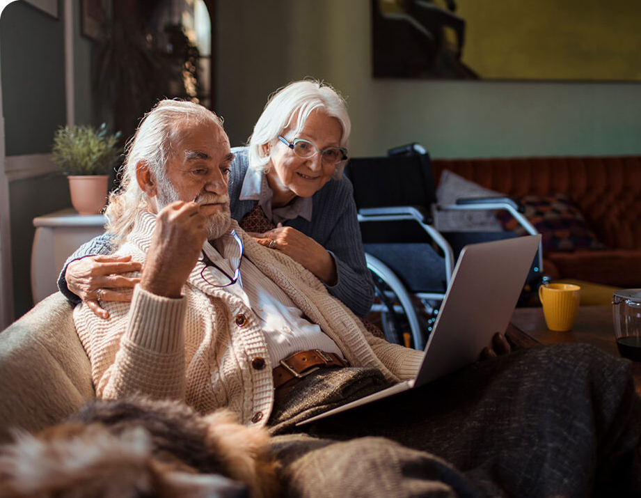 Senior couple on a couch looking at a computer together