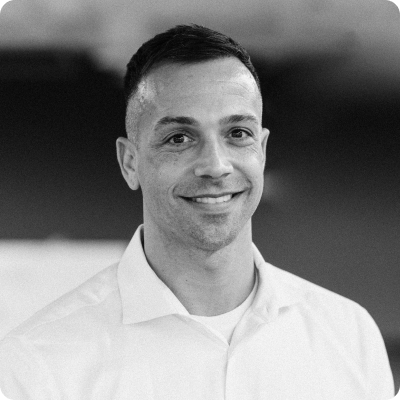 Brian Dorsey wearing a white button down shirt and smiling at the camera